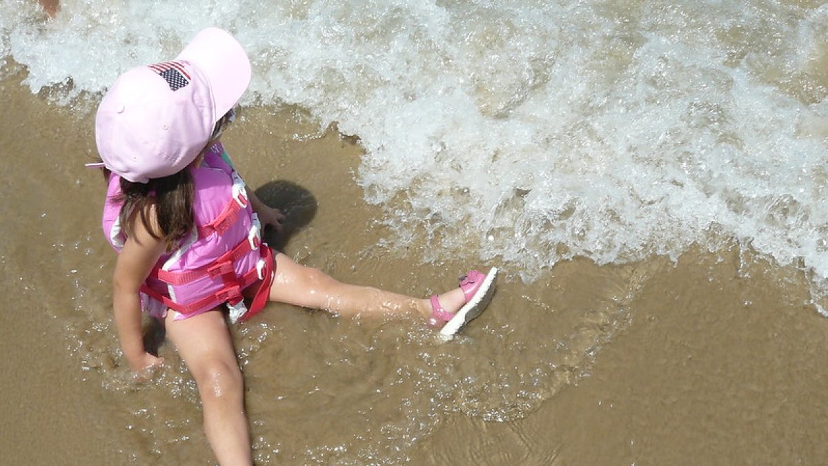 Una niña disfruta del mar.