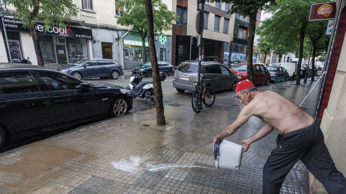 Un hombre achica agua tras la tormenta.
