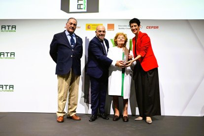 Presentación Salazar, del Mesón Burgos, recibe el premio por su trayectoria de manos de la ministra de Seguridad Social y el presidente de ATA, acompañada por su hijo Fernando.