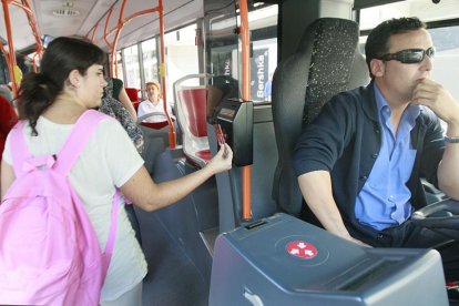 Una viajera paga el billete del bus con la tarjeta sin contacto.-RAÚL G. OCHOA