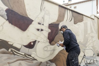 Christian Sasa trabaja en el mural del Callejón de las Brujas. SANTI OTERO