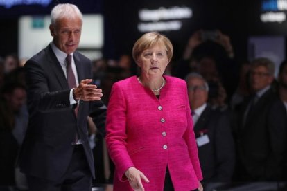 Merkel (derecha) y Matthias Mueller, presidente de Volkswagen, en el Salón Internacional del Automóvil de Fráncfort, el 14 de septiembre.-/ GETTY IMAGES / SEAN GALLUP