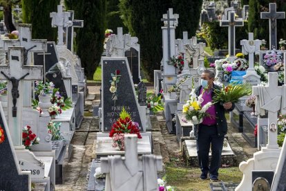 Una mujer camina entre las lápidas del cementerio. ECB