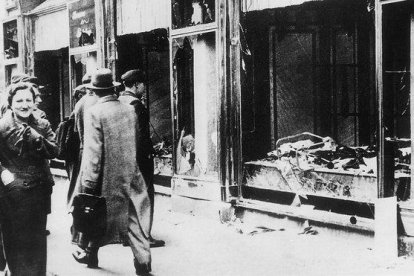 Transeúntes indiferentes ante una tienda judía destruida y saqueada en la Alemania nazi.-ARCHIVO