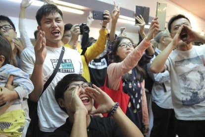 Jóvenes antigubernamentales celebran el resultado de las elecciones en Hong Kong, este domingo.-KIN CHEUNG (AP)