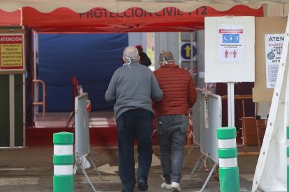 Dos hombres acceden a la carpa de triaje instalada en el HUBU. SANTI OTERO