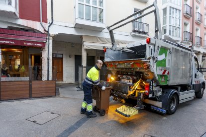 Un operario recoge un cubo de orgánico de un bar. SANTI OTERO