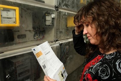 Una mujer consulta una factura eléctrica.