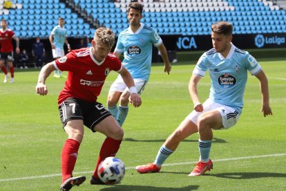 Juanma controla el balón ante la presión de la defensa celeste. BURGOS CF