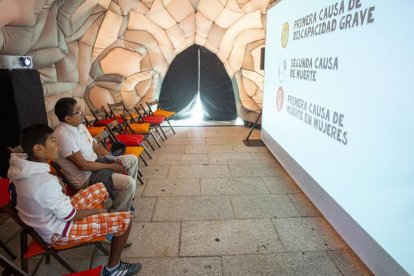 Un par de jóvenes observan el vídeo de presentación en el interior del cerebro ‘itinerante’.-SANTI OTERO