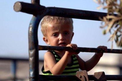 Un niño sirio llega con su familia al campo de refugiados de Idleb, en Siria.-KHALIL ASHAWI (REUTERS)