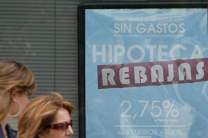 Dos mujeres pasan frente al anuncio sobre hipotecas de una entidad bancaria.-RAÚL G. OCHOA