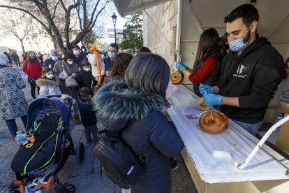 Una mujer compra los panecillos de San Lesmes durante la pasada edición de las fiestas. SANTI OTERO