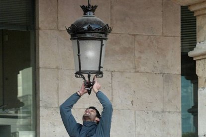 Un operario cambia una baombilla en la Plaza Mayor.-ISRAEL L. MURILLO