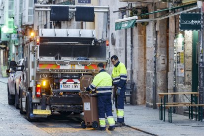 Dos operarios recogen el cubo de residuo orgánico de un establecimiento. SANTI OTERO