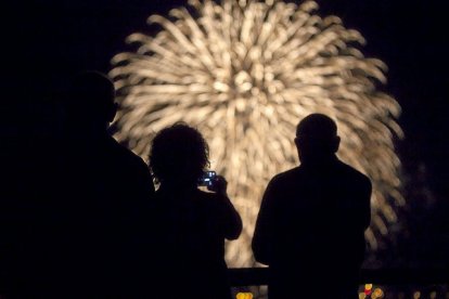 Varias personas contemplan los fuegos artificiales.-P. REQUEJO