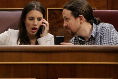 Pablo Iglesias muestra el móvil a Irene Montero durante el pleno en el Congreso.-JOSÉ LUIS ROCA