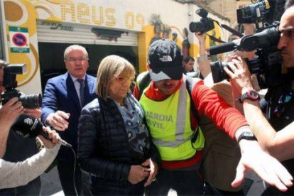 La primera teniente de alcalde del Ayuntamiento de Reus, Teresa Gomis, acompañada del alcalde de la localidad, Carles Pellicer (CiU) (izquierda), sale detenida por la puerta de atrás del ayuntamiento, el martes 28 de abril.-Foto: EFE / JAUME SELLART