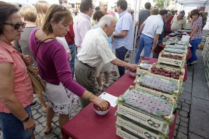 Varias personas degustan las cerezas en uno de los puestos en una edición anterior de la feria. ECB