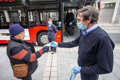 Un empleado de Autobuses entrega una mascarilla a una viajera. SANTI OTERO