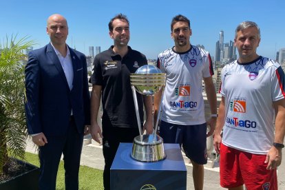 Capitanes y entrenadores de ambos equipos posan con el trofeo, en Buenos Aires. FIBA