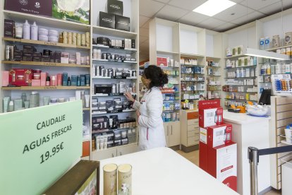 Una farmacéutica coloca los productos en una botica de la capital burgalesa. SANTI OTERO