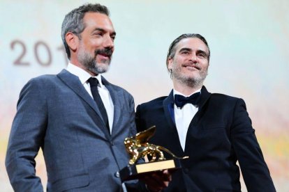 Todd Phillips sujeta el León de Oro junto al actor Joaquin Phoenix.-AFP / ALBERTO PIZZOLI