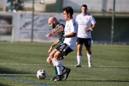 El blanquinegro, Lucas Ricoy, trata de mantener el esférico ante la presión de Óscar. Burgos CF