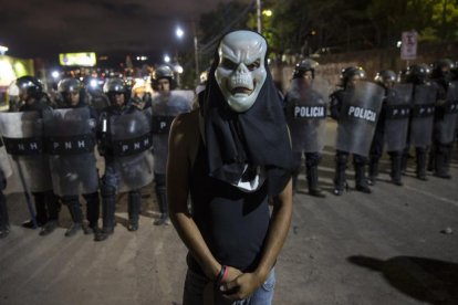 Un partidario de Salvador Nasralla ante la policía en Tegucigalpa (Honduras).-/ RODRIGO ABD (AP)