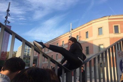 Una estudiante de la UPF, salta la valla para ir a clase, esquivando el piquete de huelga.-GEMMA TRAMULLAS