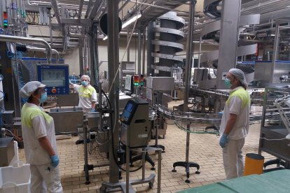 Trabajadores de la fábrica de Pascual en Aranda guardando la distancia de seguridad y con mascarilla. L. V.