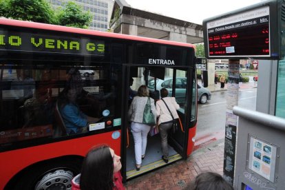 Unos usuarios suben al autobús municipal.-ISRAEL L. MURILLO