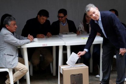 El presidente colombiano, Juan Manuel Santos, en el momento de depositar su voto en Bogotá.-REUTERS / CARLOS GARCIA RAWLINS