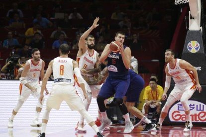 La estrella serbia Nikola Jokic (c) intenta manejar el balón ante la oposición de la defensa española.-X01757