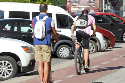 Un ciclista y un usuario del patinete comparten el carril bici en la capital burgalesa.-ISRAEL L. MURILLO