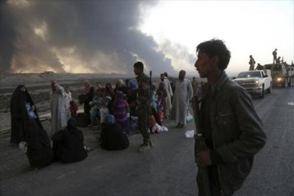 Familias iraquís, desplazadas de Mosul, cerca aún de los combates, ayer.-AP