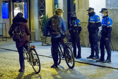Agentes de la Policía Local identifican a dos personas durante el toque de queda. ISRAEL L. MURILLO