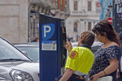 Una vigilante de la ORA explica el funcionamiento del parquímetro a una usuaria.-RAÚL G. OCHOA