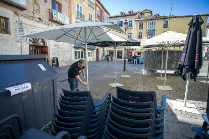 Un trabajador instala las sombrillas para la terraza de hostelería en La Flora. TOMÁS ALONSO