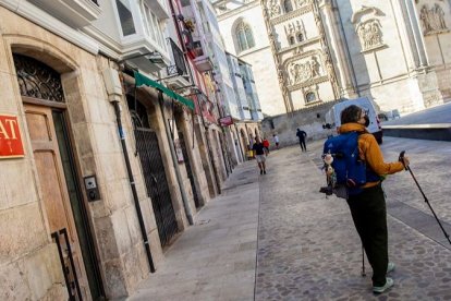 Un peregrino junto a un edificio de alojamientos turísticos en el centro histórico, que concentra la mayoría de estos pisos. SANTI OTERO