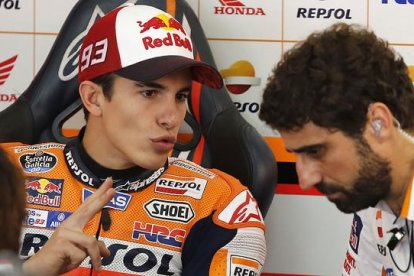 Marc Márquez conversa con un miembro de su equipo en el box de Repsol-Honda, en el circuito de Sepang.-AP / LAI SENG SIN