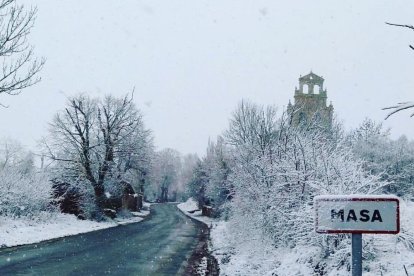 La nieve embellece más si cabe el acceso al pueblo.-KIKE DE MIGUEL