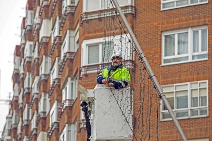 Un trabajador en la avenida Derechos Humanos colocando el alumbrado navideño. TOMÁS ALONSO