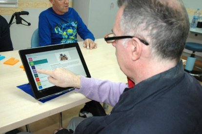 Una persona utiliza la aplicación NeuroRHB, destinada a familiares y profesionales de pacientes con daño cerebral.-EL MUNDO