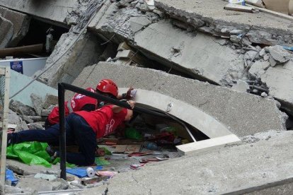 Los equipos de rescate, junto con perros rastreadores, han recuperado por el momento tres cuerpos.-EFE