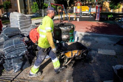 Dos operarios, ayer en la reparación de un parque infantil en la barriada Inmaculada. SANTI OTERO