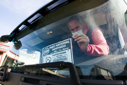 Un transportista cuelga un cartel sobre el paro en el parabrisas de su  vehículo. TOMÁS ALONSO