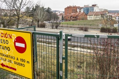Hace trece meses que los vecinos de la barriada de los Ríos se encuentran con este cartel de acceso cortado para cruzar la autovía de ronda.-ISRAEL L. MURILLO