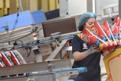 Una empleada realiza su trabajo en la línea de producción de una fábrica burgalesa de snacks.