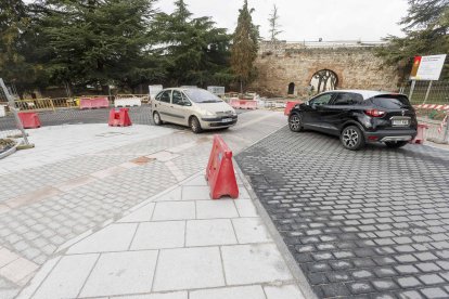 Dos vehículos circulan por la calle Santa Águeda con el arco de San Martín al fondo. SANTI OTERO